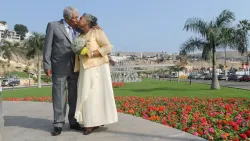 Happy Senior Couple Outdoors in Front of a Palm Tree